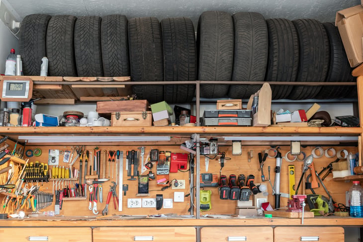 Old car tires above a tool rack in a garage