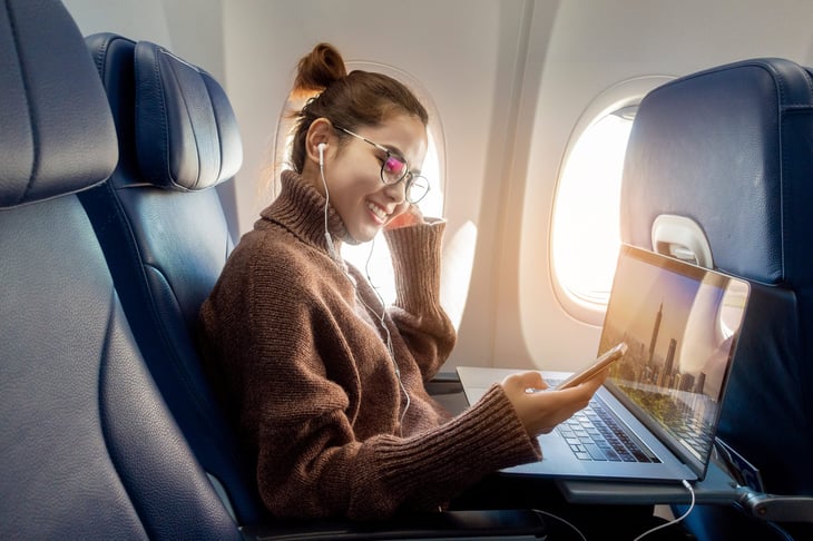 Woman using a laptop on an airplane flight