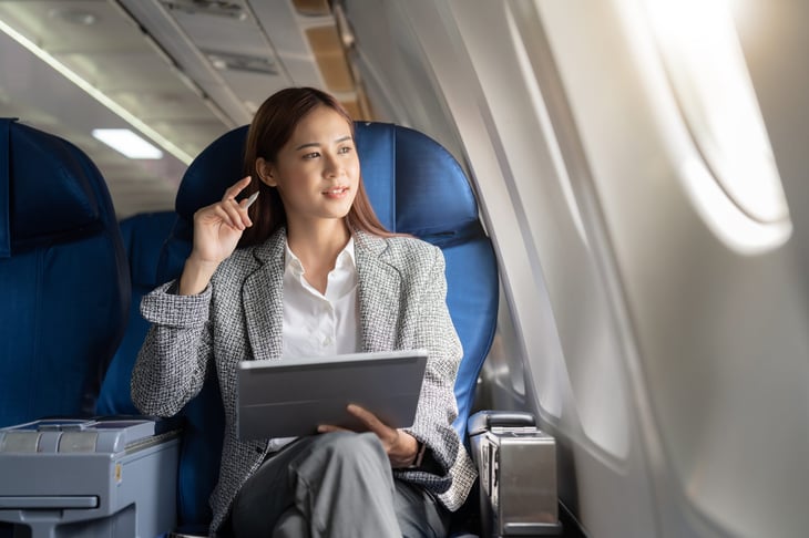 Businesswoman using a tablet on an airplane