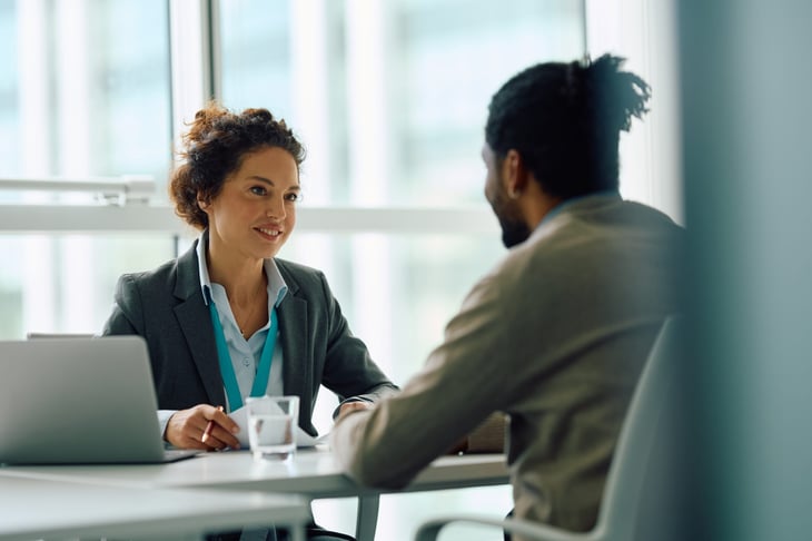 Human resource manager talking to a candidate during a job interview in an office.