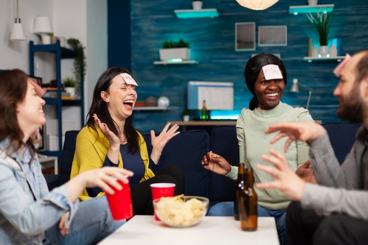 Friends playing a party game with sticky notes