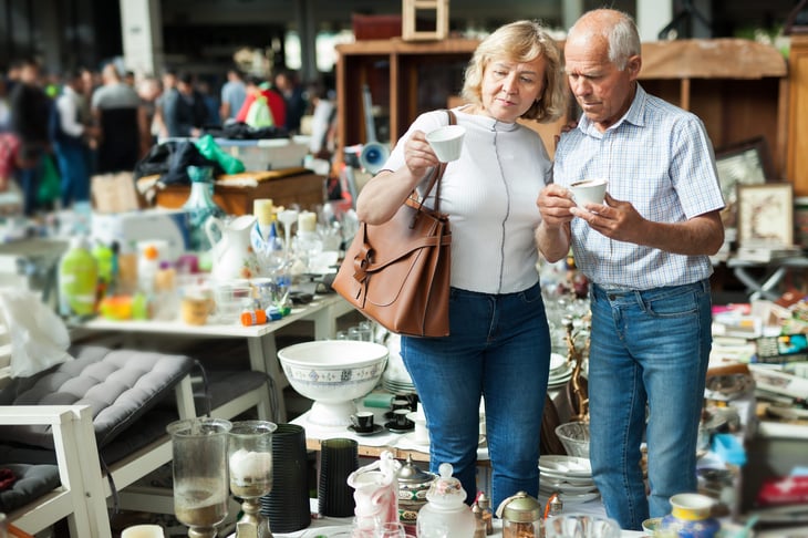 Older couple looks at vintage dishes at a flea market