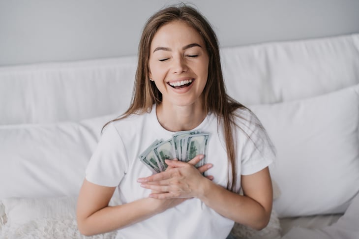 happy woman holding cash