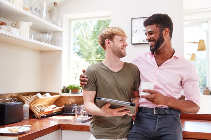 Happy couple using a tablet computer in their kitchen