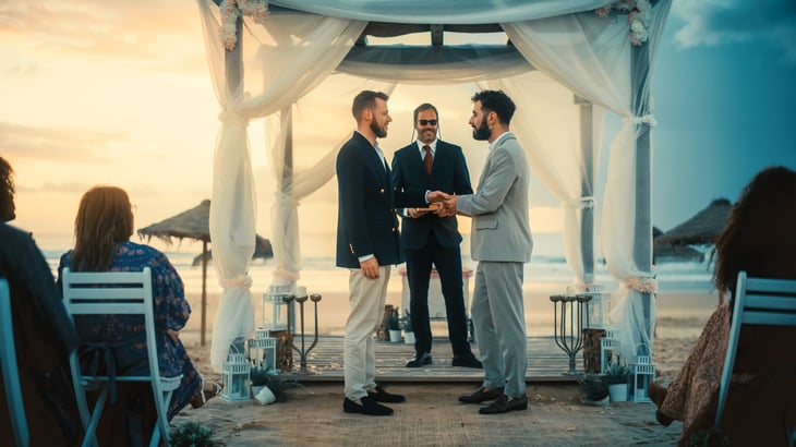 Gay Couple Exchange Rings and Kiss at a Beach Wedding Ceremony Venue at Sunset.