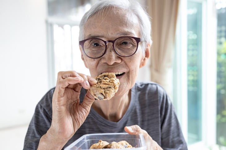 Senior woman eating junk food