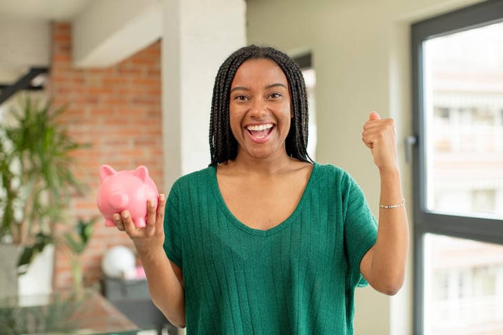 Happy woman holding a piggy bank
