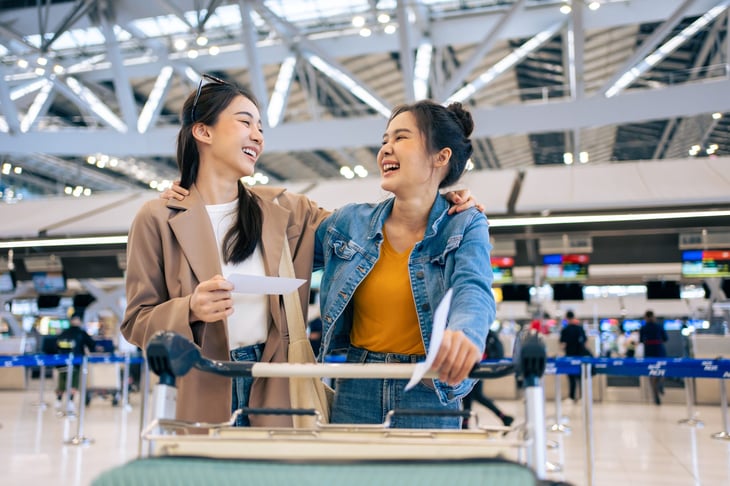 Happy friends or smiling family meeting at the airport