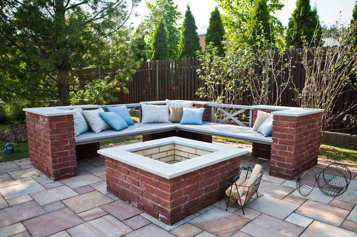 Outdoor patio with brick fireplace and bench seating