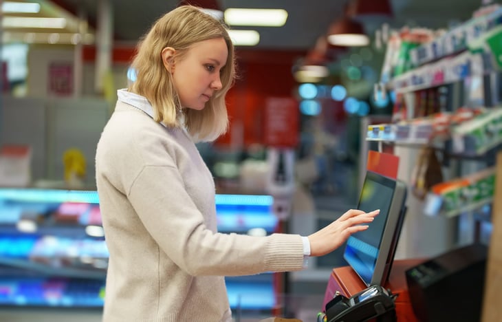 Woman using self-checkout at the grocery store