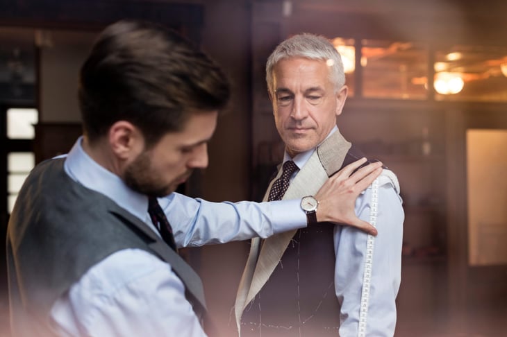 Tailor fitting a businessman for a suit
