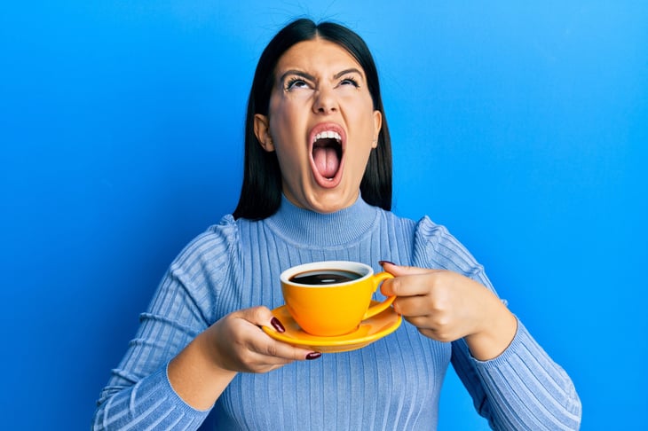 Upset woman drinking coffee
