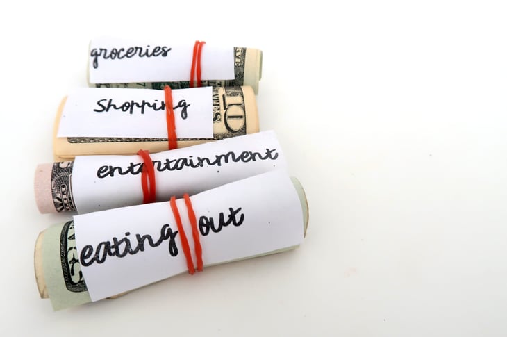 Money budget envelope method - small dollars cash wrapped with red rubber band for each categories of expenses