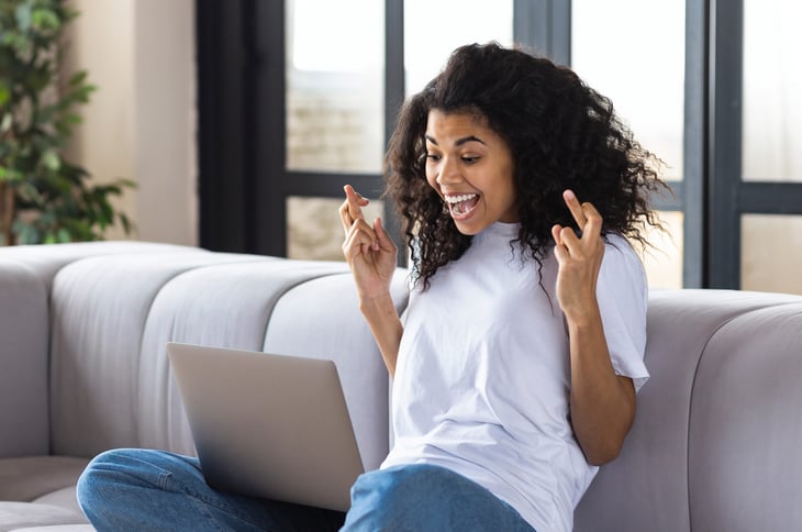 Woman with her fingers crossed checking the status of her tax refund