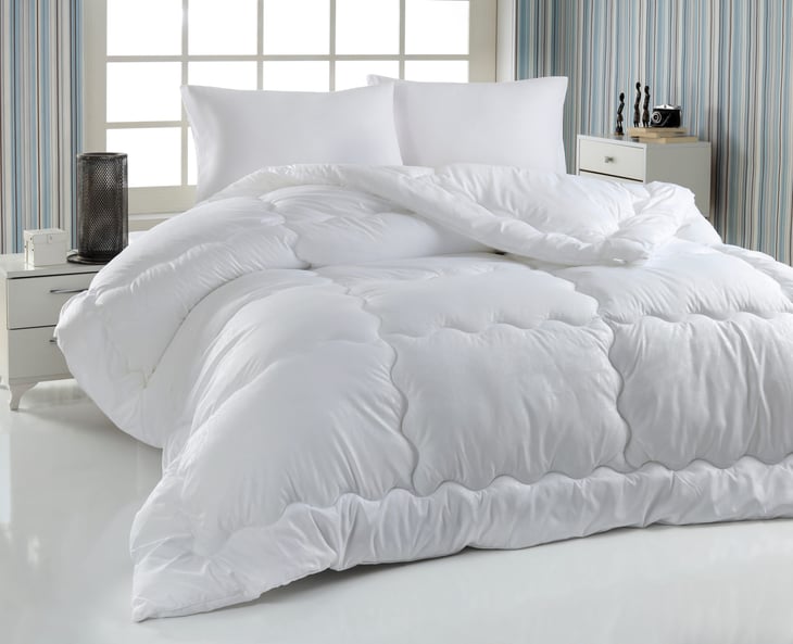 Bed with comforter or quilt and fluffy pillows