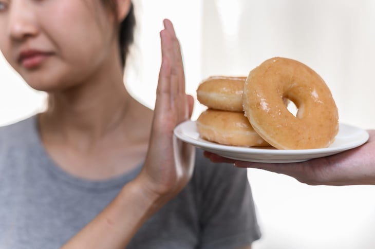 Woman pushing away doughnuts