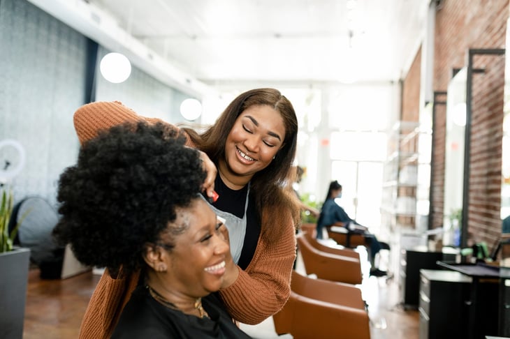 Hairstylist trimming a customer's hair at a beauty salon