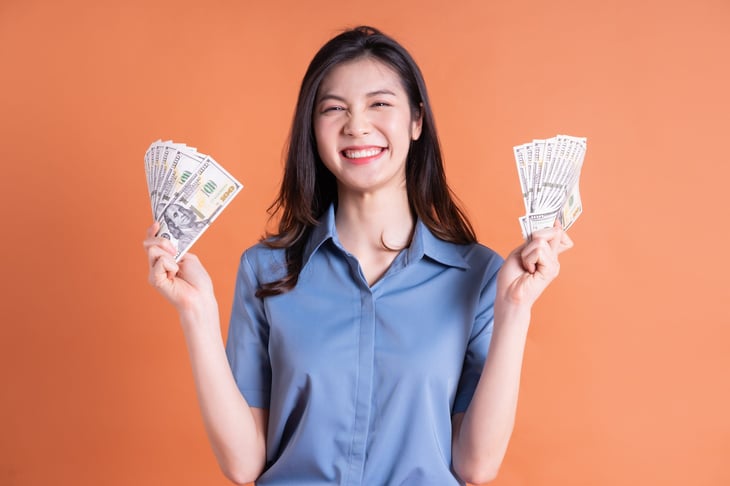 A happy woman holding money