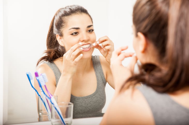 Woman using a teeth whitening kit