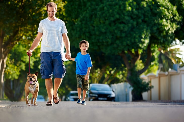 Dad walking with his dog and son in the suburbs