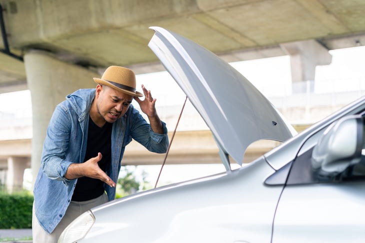Frustrated driver with broken down car
