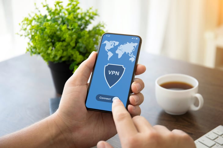 man's hands holding a phone with a VPN app on it