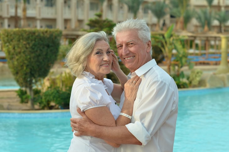 Senior couple embrace outside a hotel