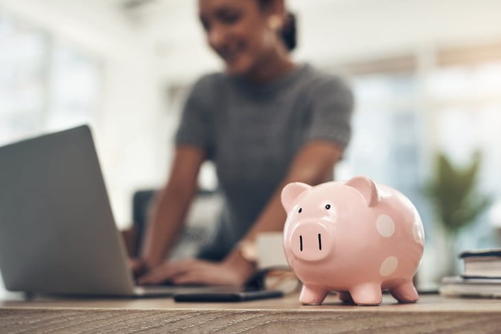 Woman working with a piggy bank on her desk