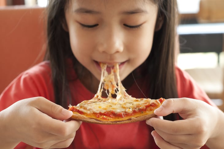 Young girl eating pizza