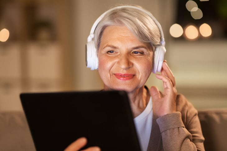 Senior woman listening to a podcast