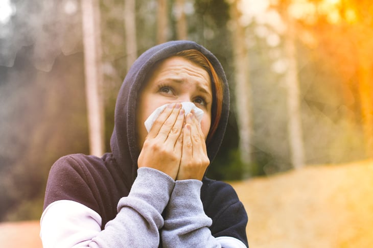 Woman covering her face from wildfire smoke