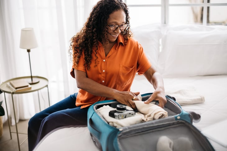 Woman unpacking her suitcase in a hotel room