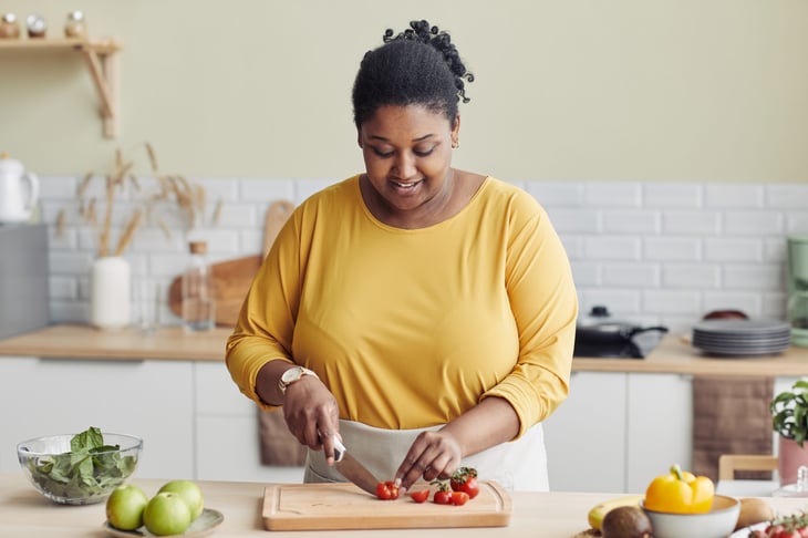 Woman chopping vegetables at home in her kitchen