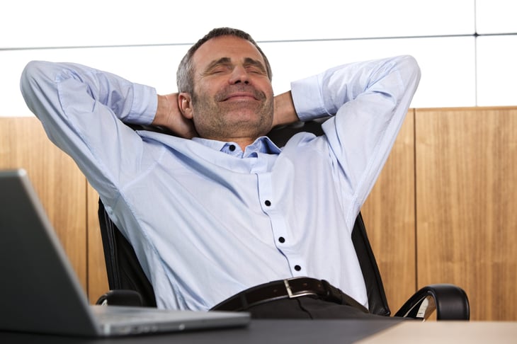 Relieved businessman or worker relaxed at a laptop not worried about work