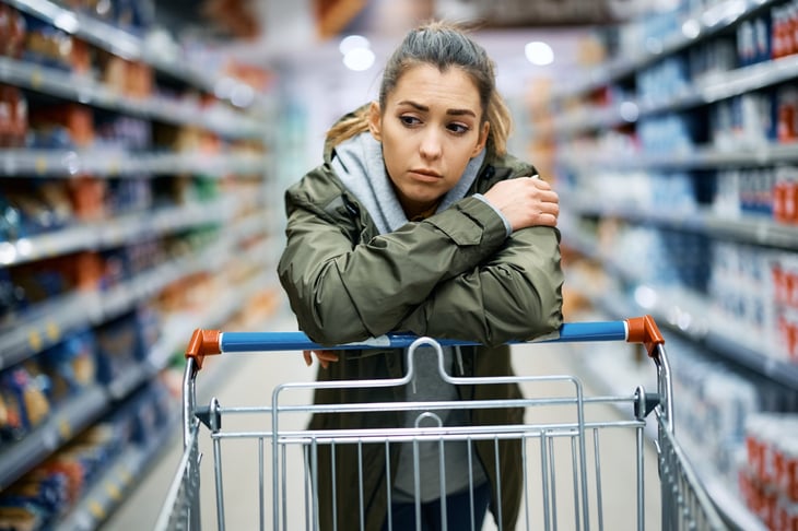Worried young woman in the grocery store