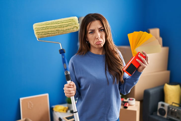 Unhappy woman with a paint roller