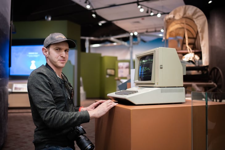 Confused or unsure man looking at an old Apple II computer