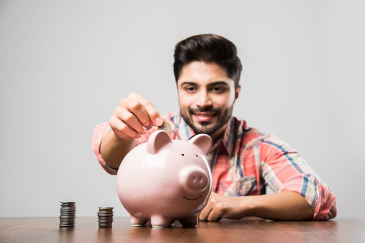 Man putting money in a piggy bank