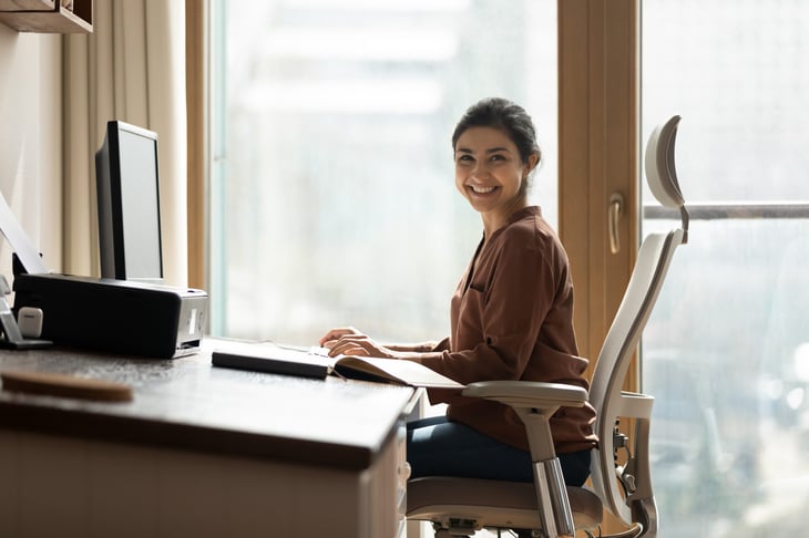 Young woman sits and works in an ergonomic chair