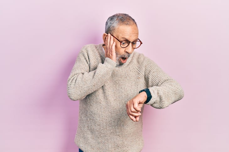 Senior man looking surprised at the time on his watch