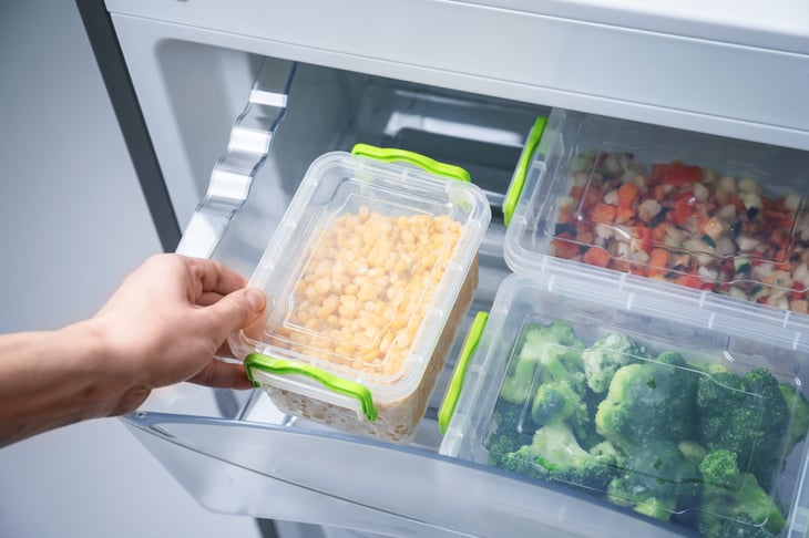 Frozen corn and broccoli in tupperware in freezer