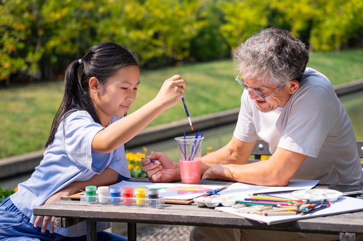 Girl and her grandfather painting