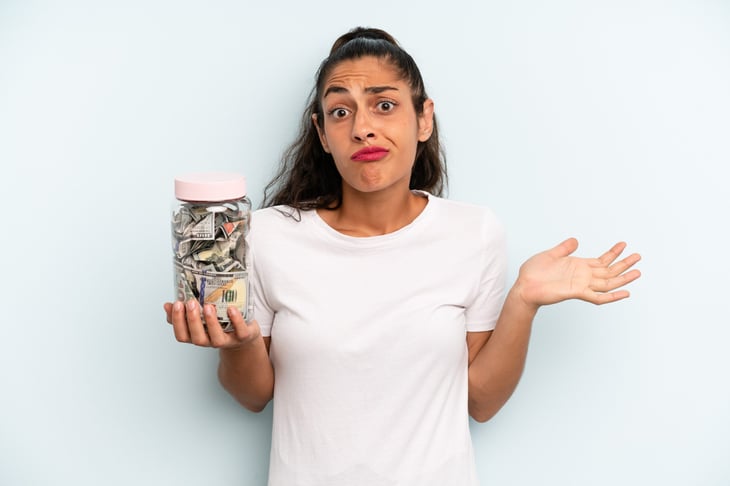 Woman holding a jar filled with money