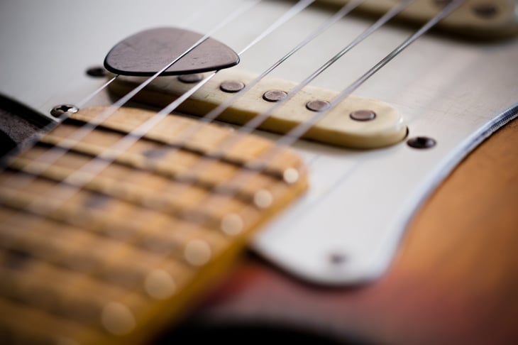 electric guitar with a pick on the strings