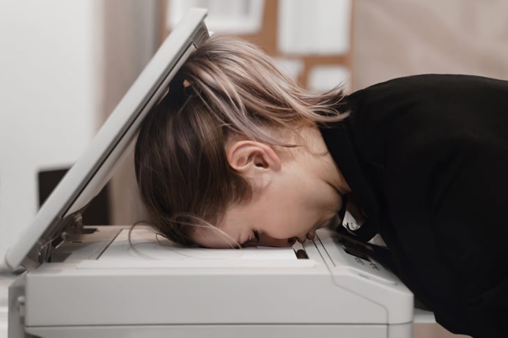 Woman using printer scanner fax at the office frustrated with work and mad at printer