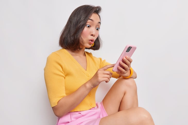 Surprised woman looking at her phone