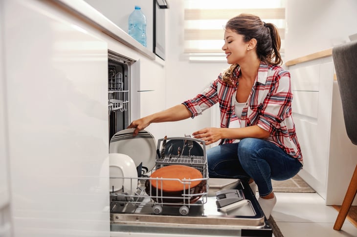 Woman filling a dishwasher