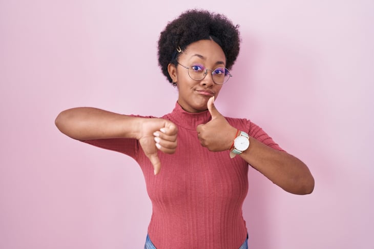 Woman giving both thumbs up and thumbs down