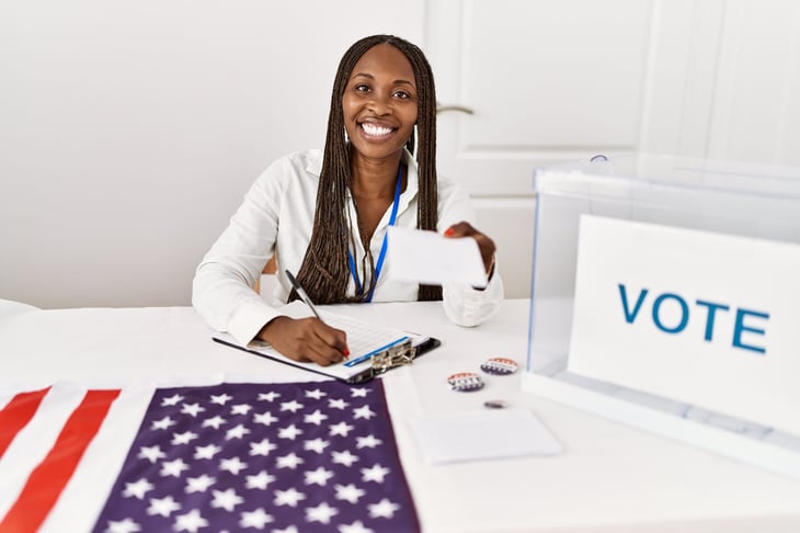 A poll worker sitting at a table