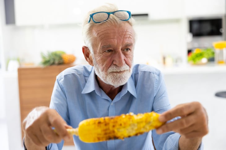 Man eating yellow corn